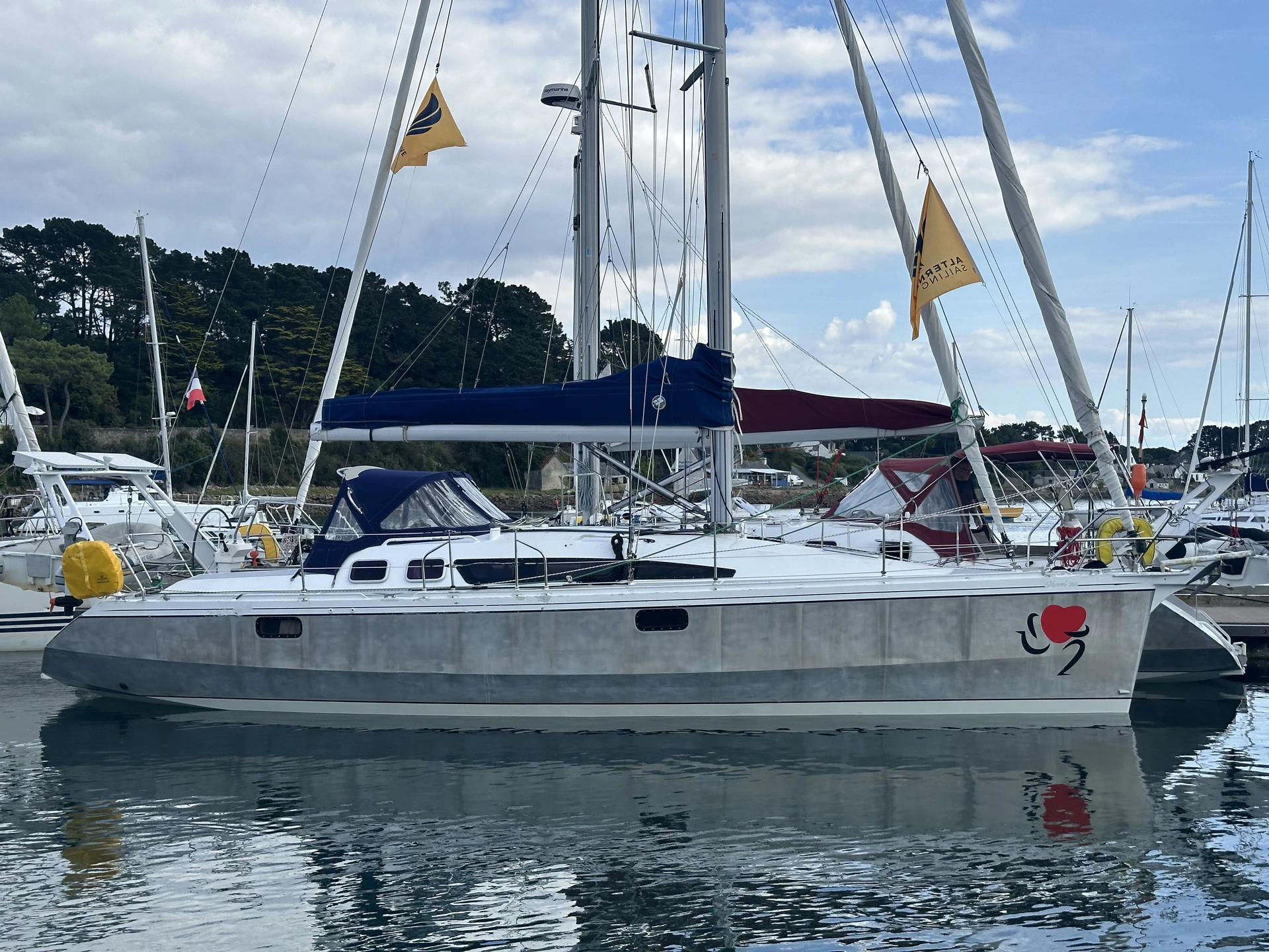 Voilier au ponton avec des pavillons Alternative Sailing
